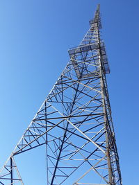 Low angle view of communications tower against clear blue sky