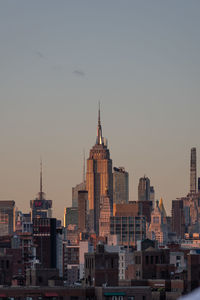 Buildings in city against clear sky