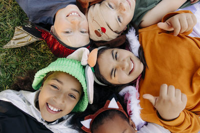 Directly above shot of happy kids lying on grass at summer camp