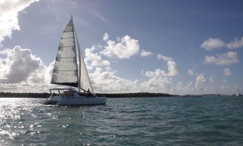 Sailboat sailing on sea against sky