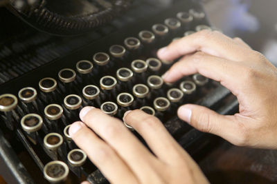 Cropped hands using typewriter at table