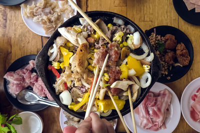 Bbq barbecue eating. people grilling  pork, meal, shellfish and shrimp with wooden chopsticks.