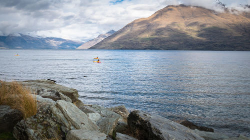 Scenic view of sea and mountains against sky