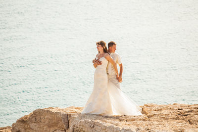 Woman with arms outstretched on sea shore