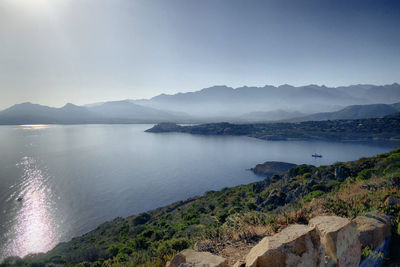 Scenic view of sea and mountains against sky