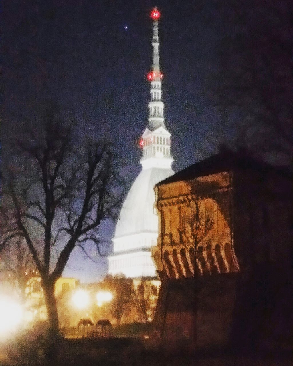 religion, spirituality, place of worship, building exterior, night, built structure, architecture, tower, church, low angle view, famous place, illuminated, tall - high, travel destinations, tourism, no people, tree, international landmark