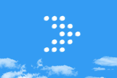 Low angle view of defocused lights against blue sky
