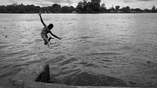 Shirtless boy diving into lake