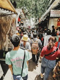 Rear view of people walking on street in city