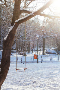 Bare trees on snow covered landscape