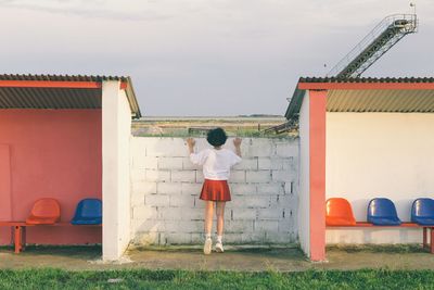 Rear view of girl standing against sky