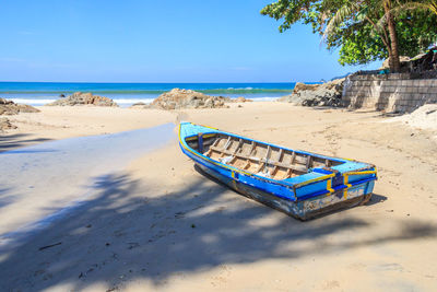 Deck chairs on beach against sky