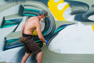Man spray painting wall