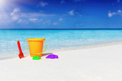 Deck chairs on beach against blue sky