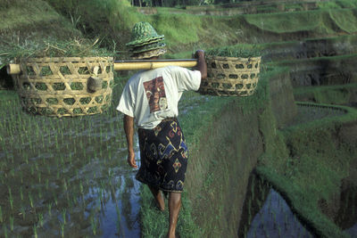 Rear view of woman standing against wall