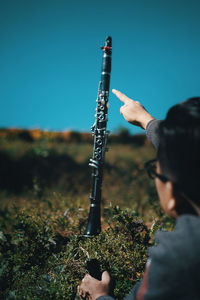 Man holding umbrella on field against clear sky