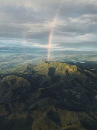 Scenic view of rainbow over land against sky