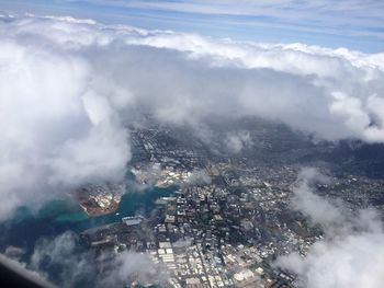 Aerial view of cityscape against cloudy sky