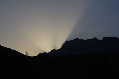 Scenic view of silhouette mountains against clear sky at sunset