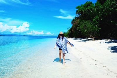 Rear view of boy walking on beach