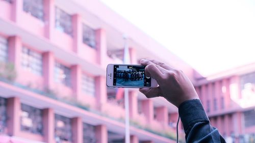 Midsection of man photographing in city