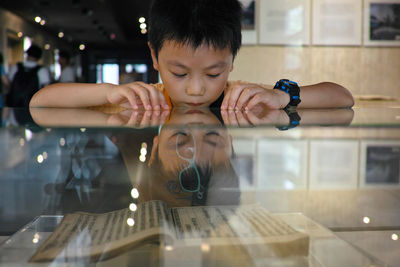 Portrait of boy holding mobile phone at table