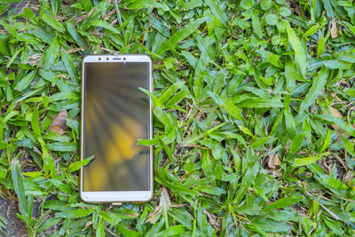 High angle view of smart phone on grass