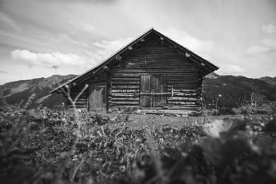 Exterior of abandoned house on field against sky