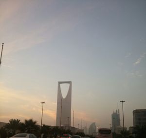 Road by city against sky during sunset