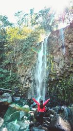 View of waterfall against trees in forest