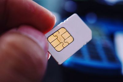 Cropped image of hand holding sim card