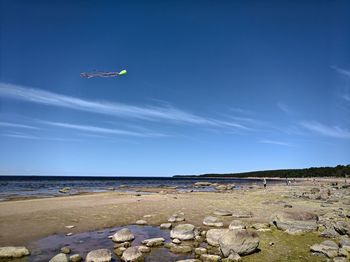 Scenic view of beach against blue sky