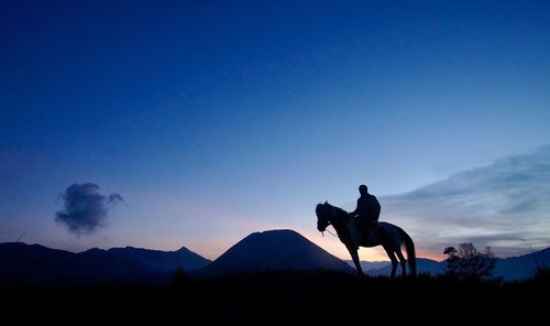 Bromo horseman in silhouette during sunrise 