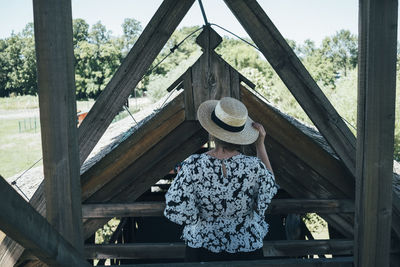 Rear view of woman standing against trees