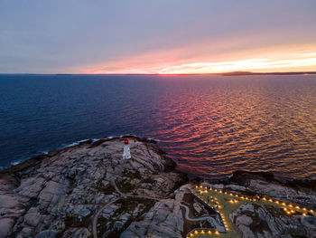 Aerial shot of peggy's point lighthouse and viewing platform at peggy's cove, nova scotia, canada