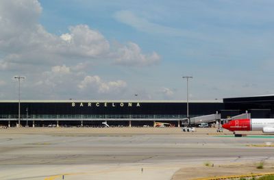 Airplane on airport runway against sky