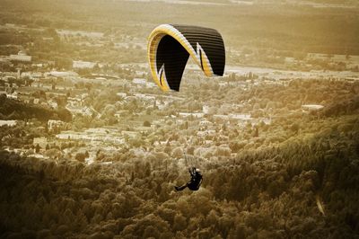 Woman paragliding over landscape