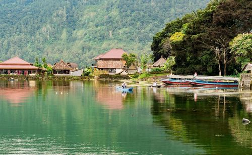 Boats moored in lake against trees