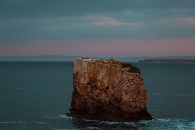 Rock formation on sea against sky