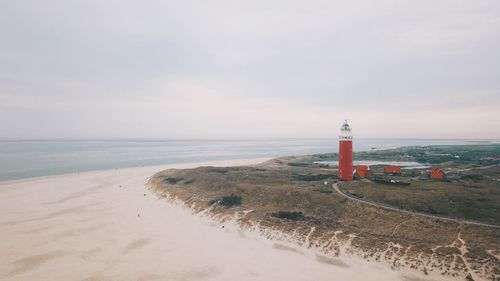 Lighthouse texel by sea against sky