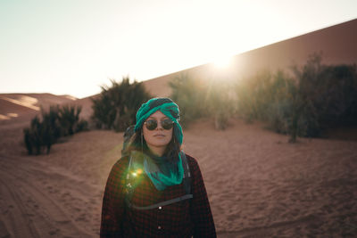 Portrait of woman standing on land against sky during sunset