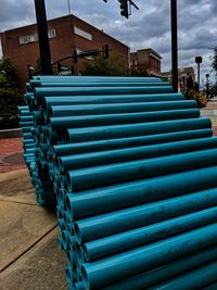 Stack of empty seats on street against buildings