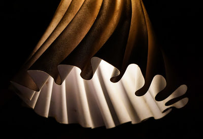 Illuminated lamp against black background