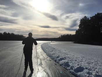 Rear view of man on snow covered landscape