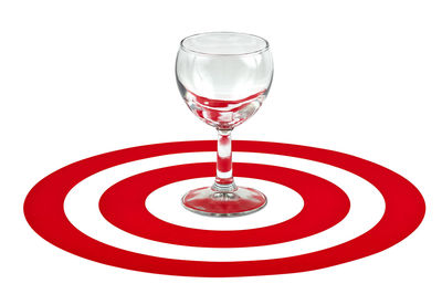 Close-up of red wine glass against white background