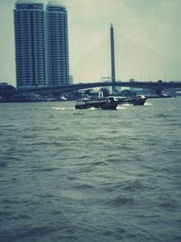Boats in river with buildings in background