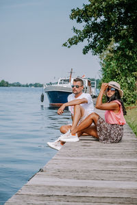 Woman sitting on boat against sky