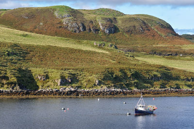 Sailboats on sea against mountains