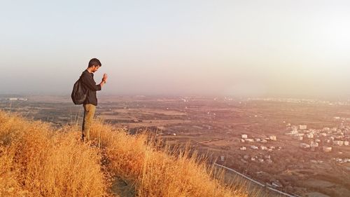 Man standing on mountain against sky