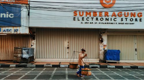 Side view of a woman standing against building